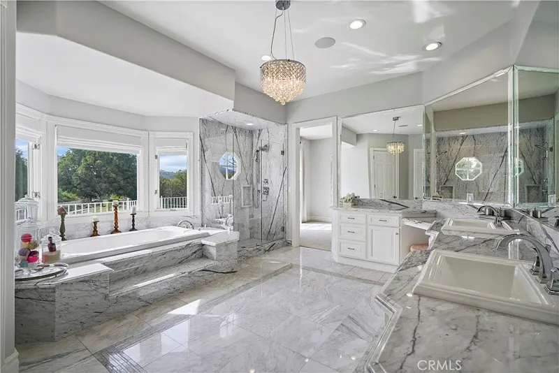 Primary bath in marble with bay-window tub at One Zoom Listing