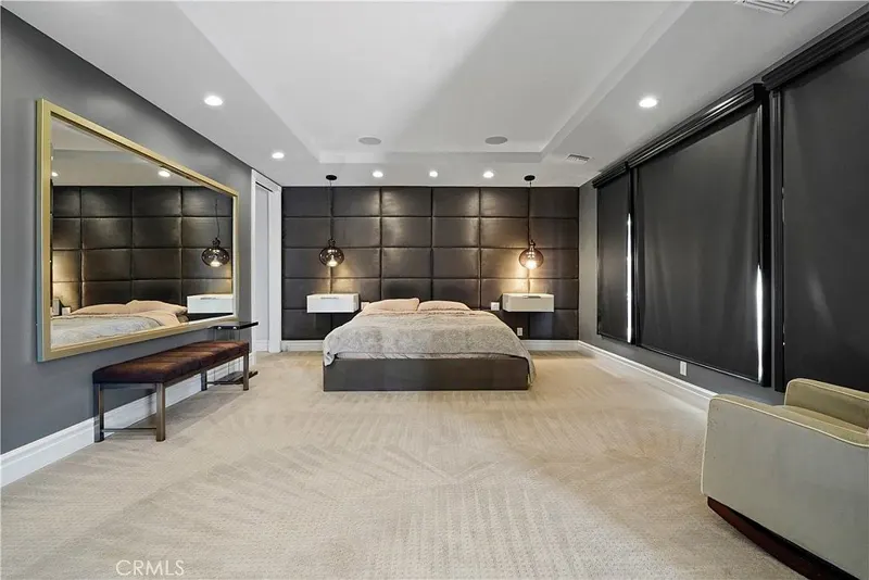 Primary bedroom with upholstered wall and blackout drapery at One Zoom Listing