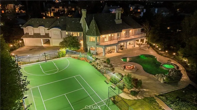 Night aerial over the lit sport court and grounds at One Zoom Listing