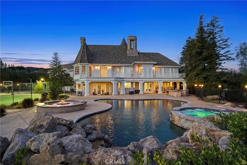 Rear elevation across the pool and spa at twilight at One Zoom Listing